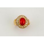 An 18ct gold (tested, unhallmarked) coral and diamond ring, the coral approx 1.50ct, bordered with