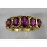 An 18ct gold, ruby and diamond ring, set with five graduated rubies, the largest measuring 5mm long,