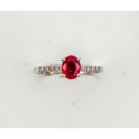 A 14ct white gold, ruby and diamond ring, the oval cut ruby approx 1ct, set iwth diamonds to the