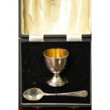 A silver egg cup with later silver plated spoon, in original presentation box Wilson & Gill of