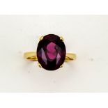 A 9ct yellow gold and oval almandine garnet solitaire cocktail ring, the garnet approx 5.50ct,