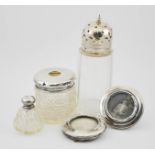 A silver and glass dressing table pot and jar, two silver picture frames, and a silver plated