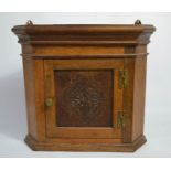 A small oak corner cupboard, with carved door.