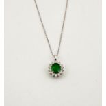 An 18ct white gold, emerald and diamond pendant necklace, the oval cut 1ct emerald bordered by 0.