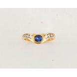 An 18ct gold, sapphire and diamond ring, in the wishbone style, with an oval cut sapphire, size