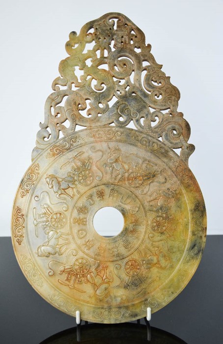 A Chinese hand carved natural jade plaque of dragons and phoenix design, with figures on horse and