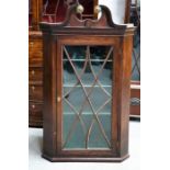 A 19th century mahogany corner cupboard with split swan neck pediment and astrigal glazed door,