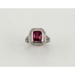An 18ct white gold and rhodolite garnet and diamond ring, the cushion cut garnet approximately