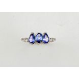 An 18ct white gold, diamond and tanzanite ring, the three pear cut tanzanites totalling 1.50ct, with