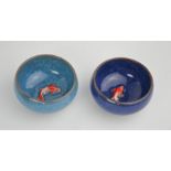 A pair of Chinese handcarved painted enamelled tea bowls with embossed goldfish to the centres.