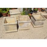 A set of four stone planters, square form, classical fluted style, 44cm high, 46cm square.