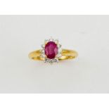 An 18ct yellow gold, ruby and diamond ring, the ruby approx 1ct, bordered by 0.33ct diamonds, size