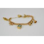 A 9ct gold charm bracelet, with six charms including ram, lantern, bell, violin, shoe and 1 pound