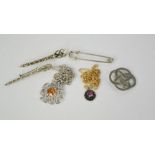 A group of vintage Scottish pendants, brooches, and a kilt pin, one pendant stamped CJ Scotland,