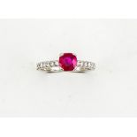 A platinum and ruby solitaire ring, set with diamonds to the shoulders, the ruby approx 0.90cts,