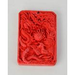 A Chinese carved cinnebar dragon pendant