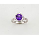 An 18ct gold, amethyst and diamond ring, the brilliant cut amethyst 1.52ct, the bordering diamonds