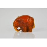 An amber netsuke bead in the form of an elephant, carved with detail, 3cm high.