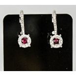 A pair of 18ct white gold ruby and diamond drop cluster earrings, the ruby approx 0.30cts, the