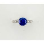 A 14ct white gold, sapphire and diamond ring, the cushion cut sapphire approx 2ct, set with