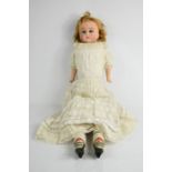 An early 20th century wax head German doll, with lace work dress and painted wooden hands and