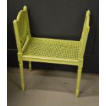 A French window seat with caned sides and seat, painted green, 73 by 59 by 35½cm.