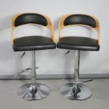 Two modern beech and faux leather bar stools.
