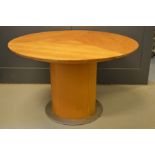 A Skovby patented extending table dining table with circular top.
