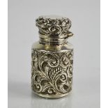 A silver 19th century scent bottle, with glass liner, embossed with scroll work decoration, 5½cm