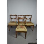 A set of four Victorian rosewood chairs, with foliate carved back rail, needlework upholstered