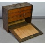 A carpenters tool chest with drawers to the interior and a drop down front, with key.