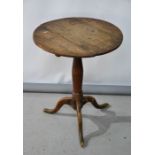 An oak tripod table with circular top, 63cm high.