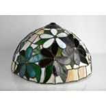 A Tiffany style glass lamp shade composed of coloured glass panels forming flowers.