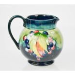 A Moorcroft jug in the grape and leaf pattern, bearing impressed mark and blue painted William