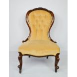 A Victorian walnut nursing chair, with yellow velvet button back and seat. 93cms tall