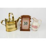 An antique desk calendar 21cm high, brass watering can and Victorian red and white jug.