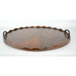A 19th century oyster veneered walnut oval tray, with wavy edge and white metal clad handles, 55