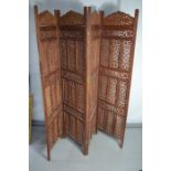 An Indonesian carved four fold screen, each panel carved and pierced with floral design and measures