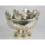 A Victorian silver punch bowl, with shaped rim embossed with face masks, above a gadrooned body