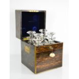 A 19th century coromandel tantalus containing four cut glass decanters, with blue velvet lined
