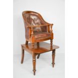 A Victorian childrens bergere chair on stand with leather button back, the mahogany stand raised