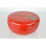 A Japanese red lacquered box, engraved with a flower and signature, 20cm diameter.