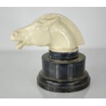 A horse head mascot, white painted metal, raised on an ebonised socle base, 18cm high.