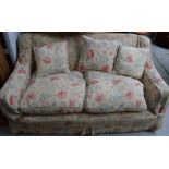 An Edwardian two seater settee, upholstered in floral pattern.