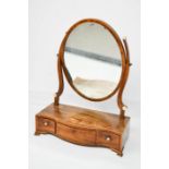 A 19th century mahogany toilet mirror, the oval mirror raised above a serpentine base with three