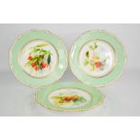 Three Royal Worcester plates by Frank Robert, decorated with flowers, with green boarder and