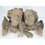 A 19th century Italian carved oak pair of winged cherub heads, 30 by 38cm.