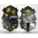A pair of Victorian black lacquered folding wall sconces, the shaped backs hand painted with various