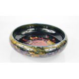 A Moorcroft bowl, shallow form, in the pomegranate pattern, green painted William Moorcroft