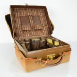 A Shortland Fooks of Brighton leather travelling vanity case, containing silver topped bottles, hair